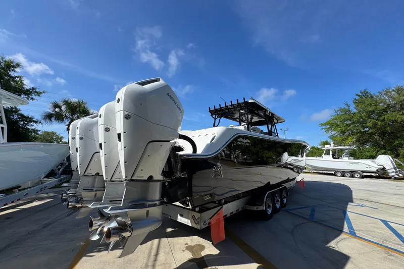 Slide: The Image of 2022 Invincible 46 Catamaran with powerful outboard engines, parked on a sunny day. - 9