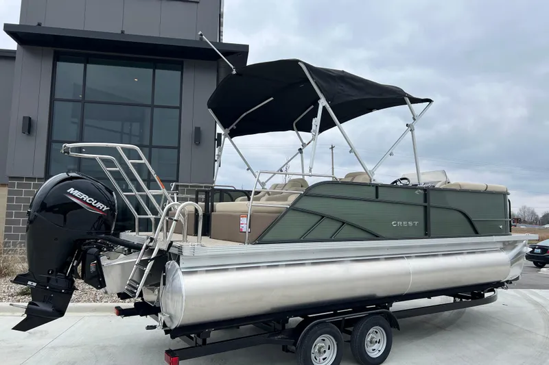 Slide: The Image of 2024 Crest Classic LX 220 SLRC pontoon boat with Mercury engine on trailer. - 2