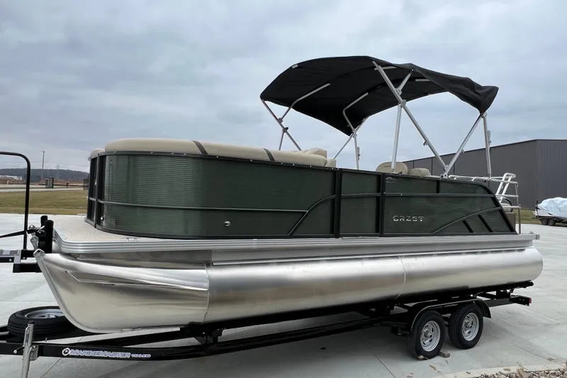 Slide: The Image of 2024 Crest Classic LX 220 SLRC pontoon boat on trailer, outdoor setting. - 6