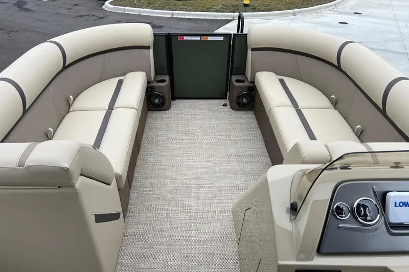 Slide: The Image of 2024 Crest Classic LX 220 SLRC pontoon boat interior with beige seating and dashboard. - 9