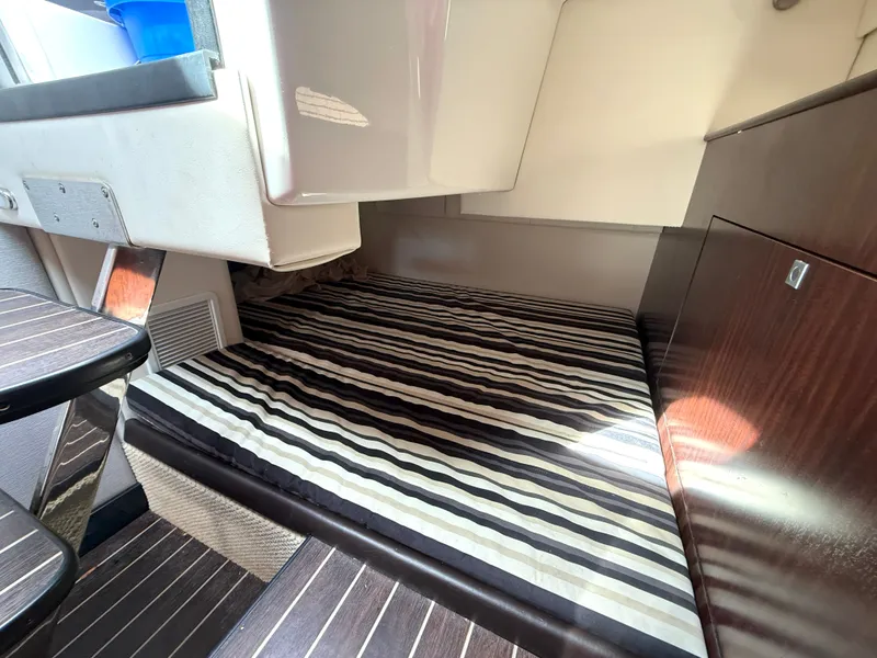 Slide: The Image of Interior of 2019 Monterey SPORT YACHT 295 with striped bedding. - 19