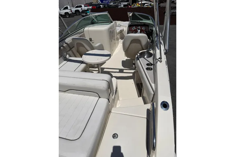 Slide: The Image of 2010 Sea Ray 230 Sundeck interior with seating, table, and dashboard. - 3
