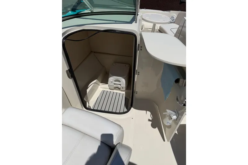 Slide: The Image of 2010 Sea Ray 230 Sundeck boat interior with open compartment and seating area. - 6