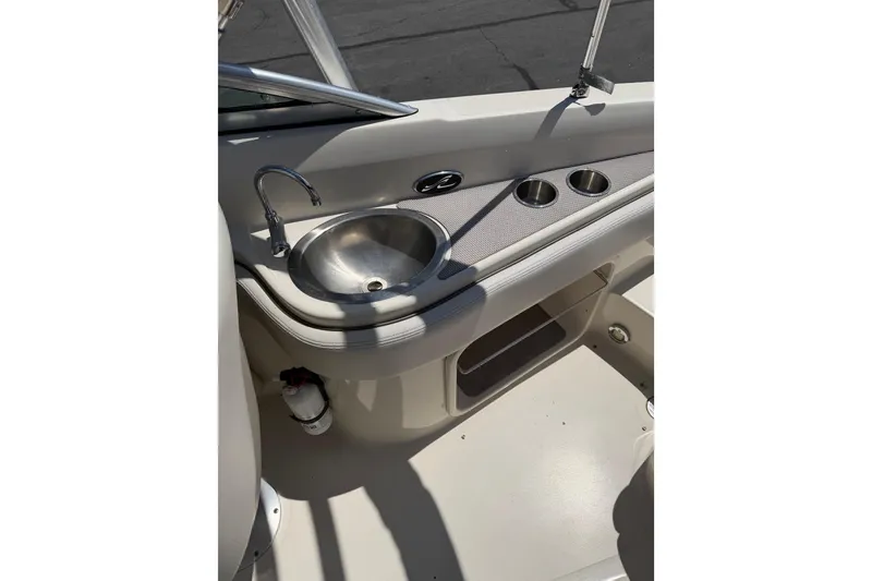 Slide: The Image of 2010 Sea Ray 230 Sundeck boat interior with sink and cup holders. - 9