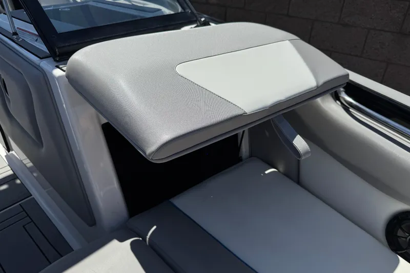 Slide: The Image of 2019 Moomba Max boat interior with gray cushioned seating and storage compartment. - 14