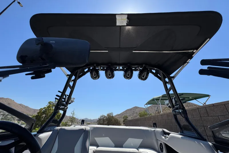 Slide: The Image of 2019 Moomba Max boat interior with speakers and canopy, set against a clear blue sky. - 16