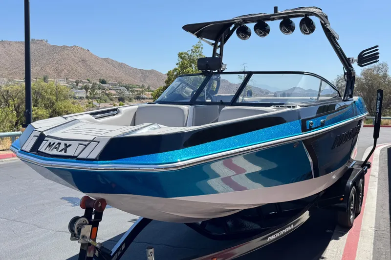 Slide: The Image of 2019 Moomba Max boat on trailer, blue and black design, mountainous background. - 3