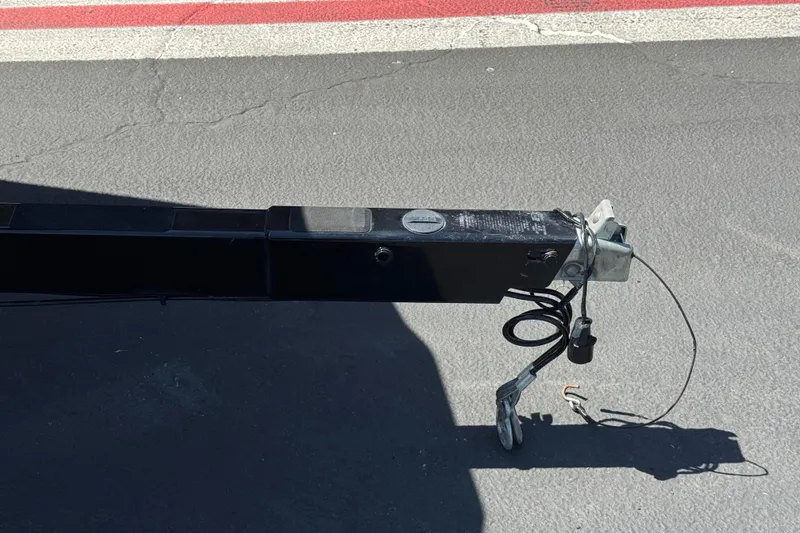 Slide: The Image of Trailer hitch of a 2019 Moomba Max on asphalt, featuring cables and connectors. - 38