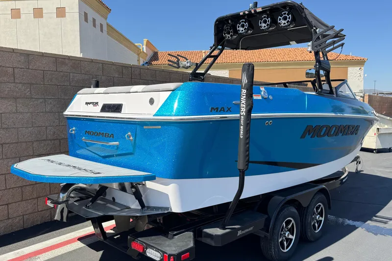 Slide: The Image of 2019 Moomba Max boat in vibrant blue, parked on a trailer in a sunny setting. - 5