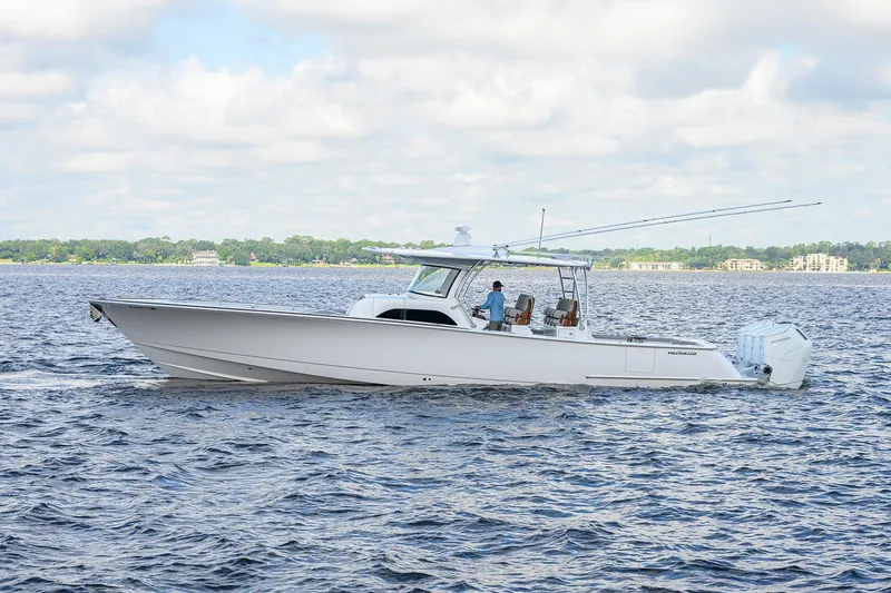 Slide: The Image of 2026 Valhalla V-46 boat cruising on a calm lake under a partly cloudy sky. - 6