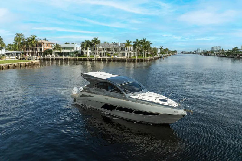 Slide: The Image of 2025 Valiatt 410HT yacht cruising on a scenic waterway with luxury homes in the background. - 5