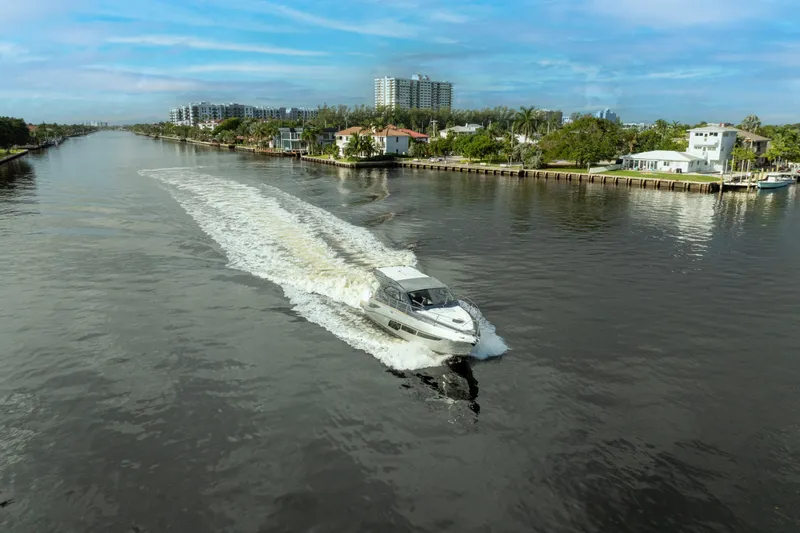 Slide: The Image of Valiatt 410HT 2025 cruising on a scenic river with waterfront homes. - 7