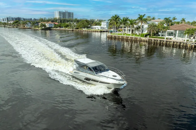 Slide: The Image of 2025 Valiatt 410HT yacht cruising on a scenic waterway with waterfront homes. - 8