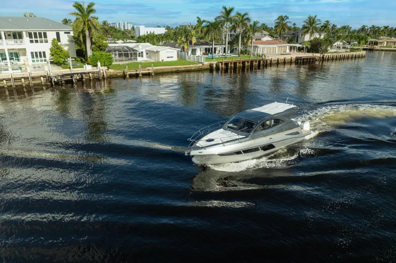 Slide: The Image of Luxury Valiatt 410HT yacht cruising near waterfront homes, 2025 model. - 9