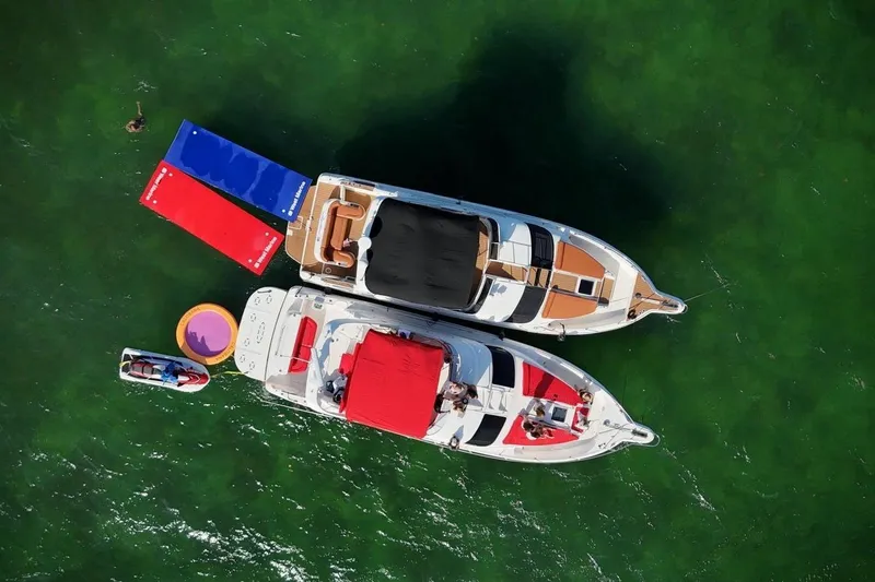 Slide: The Image of Aerial view of 2002 Sea Ray 450 Express Bridge yacht with colorful floats in green water. - 11