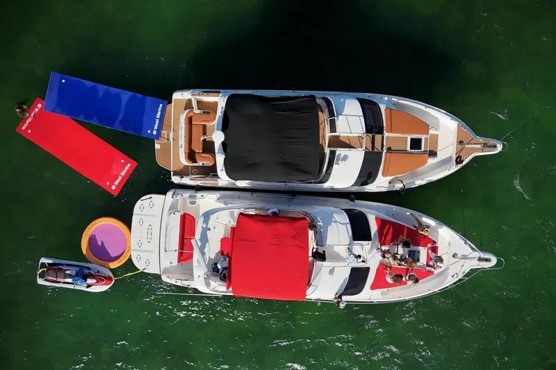 Slide: The Image of Overhead view of two Sea Ray 450 Express Bridge yachts, 2002 model, with colorful mats on water. - 14