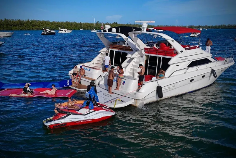 Slide: The Image of 2002 Sea Ray 450 Express Bridge with people enjoying water activities nearby. - 16