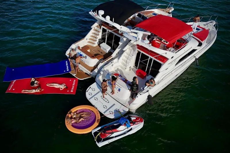 Slide: The Image of 2002 Sea Ray 450 Express Bridge with people enjoying water activities and sunbathing. - 18