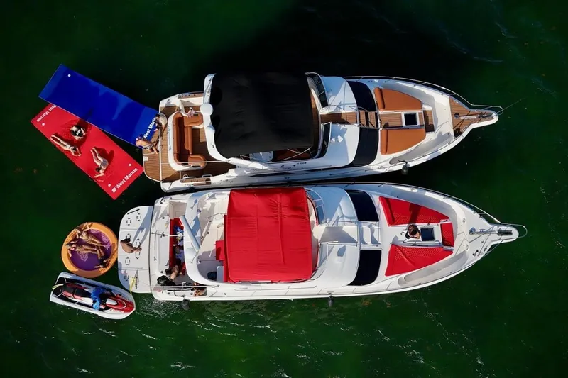 Slide: The Image of Overhead view of 2002 Sea Ray 450 Express Bridge with people relaxing on floats. - 2