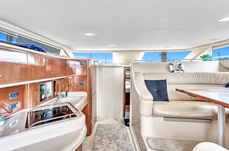 Slide: The Image of Interior of 2002 Sea Ray 450 Express Bridge yacht with kitchen and seating area. - 29