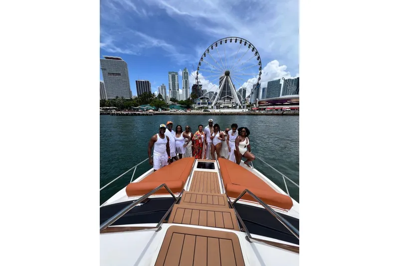 Slide: The Image of Group enjoying a day on a 2002 Sea Ray 450 Express Bridge yacht with cityscape and Ferris wheel backdrop. - 3