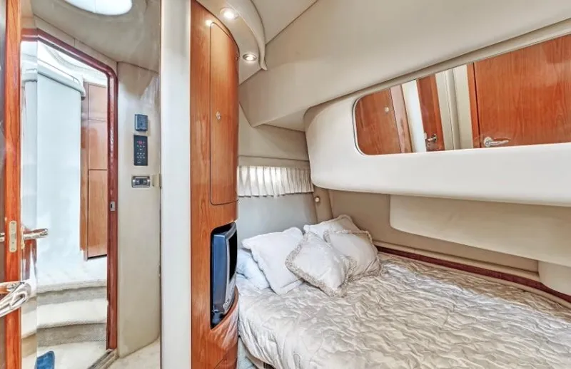 Slide: The Image of Interior cabin of 2002 Sea Ray 450 Express Bridge yacht, featuring a cozy bed and wooden accents. - 31