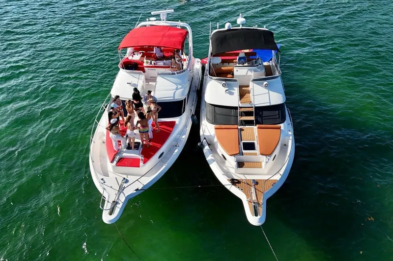 Slide: The Image of Two yachts, including a 2002 Sea Ray 450 Express Bridge, anchored together on clear water. - 6