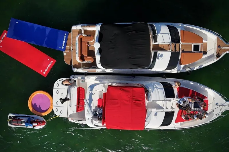 Slide: The Image of Overhead view of two Sea Ray 450 Express Bridge yachts, 2002 model, with colorful mats and people. - 7