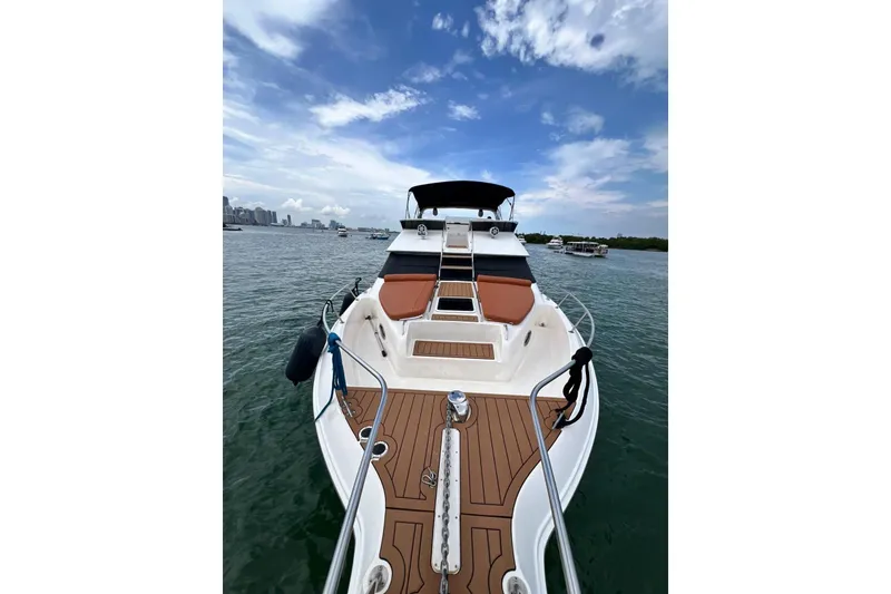 Slide: The Image of 2002 Sea Ray 450 Express Bridge yacht on water, featuring spacious deck and sleek design. - 8