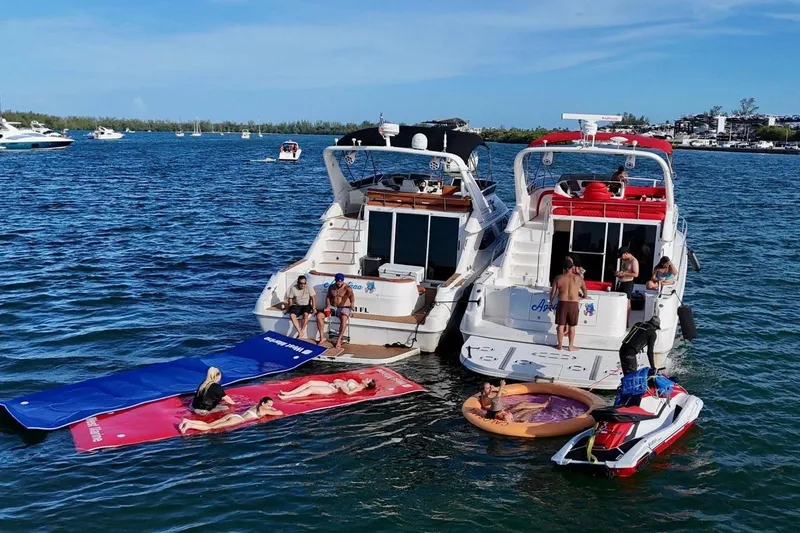 Slide: The Image of Two Sea Ray 450 Express Bridge yachts with people enjoying water activities nearby. - 9