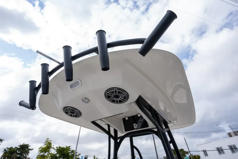 Slide: The Image of 2025 Pathfinder 2400 Open boat's T-top with rod holders and speakers against cloudy sky. - 8