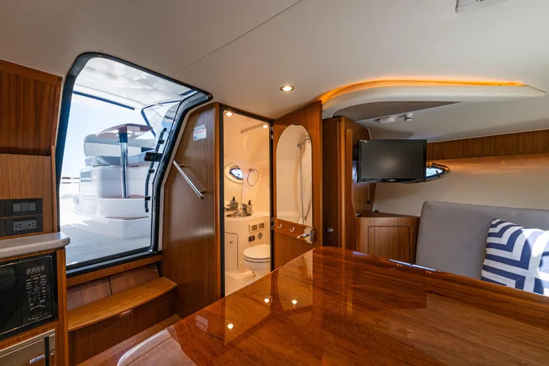 Slide: The Image of 2018 Tiara Yachts 3100 Coronet interior with wood finish, seating, and bathroom. - 20