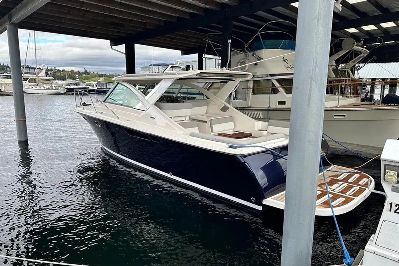 Slide: The Image of 2018 Tiara Yachts 31 docked under a covered marina, showcasing sleek design and luxury. - 27