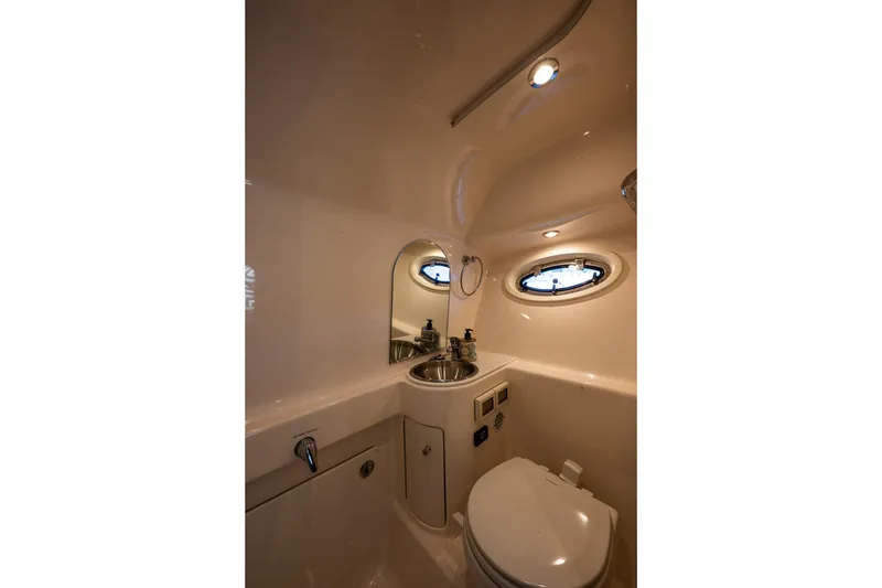 Slide: The Image of 2018 Tiara Yachts 3100 Coronet bathroom with sink, toilet, and porthole window. - 29