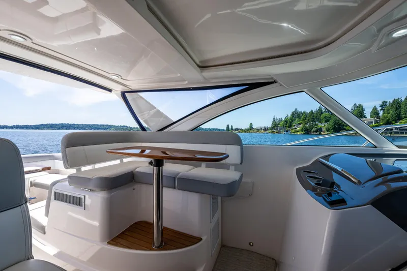 Slide: The Image of 2018 Tiara Yachts 3100 Coronet interior with seating and table, overlooking scenic water view. - 32