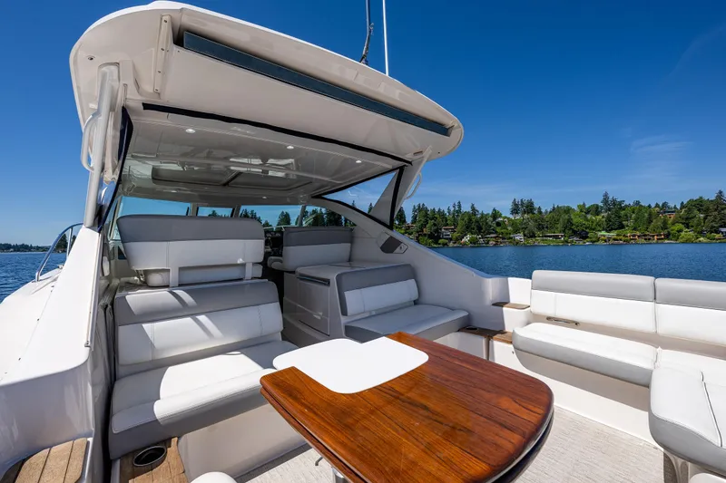 Slide: The Image of 2018 Tiara Yachts 3100 Coronet interior with seating and table, overlooking serene lake. - 34
