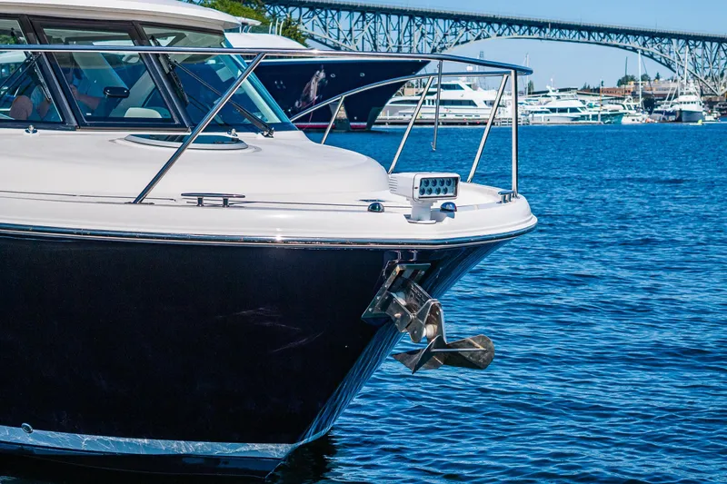 Slide: The Image of 2018 Tiara Yachts 31 boat docked on blue water near a bridge. - 6