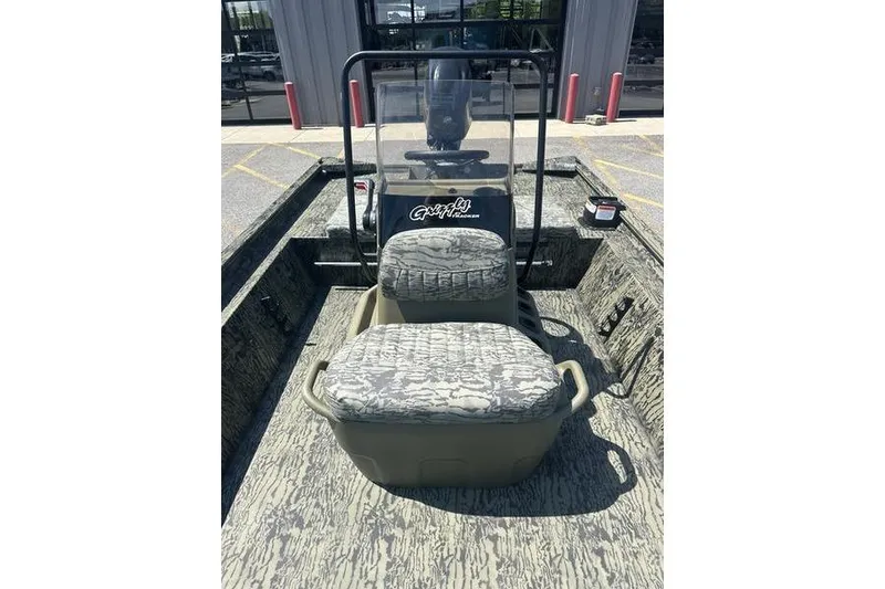 Slide: The Image of 2026 Tracker Grizzly 1860 CC boat interior with camouflage seating and steering console. - 10