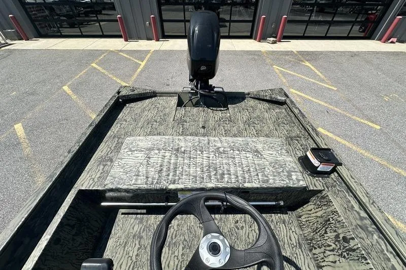 Slide: The Image of 2026 Tracker Grizzly 1860 CC boat interior with steering wheel and camouflage design. - 9