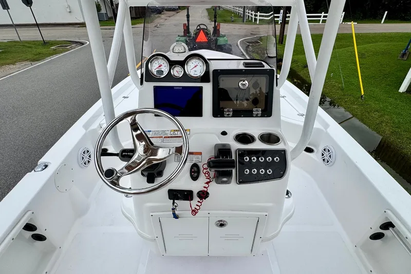 Slide: The Image of 2024 NauticStar 214 Bay boat dashboard with steering wheel and control panel. - 10