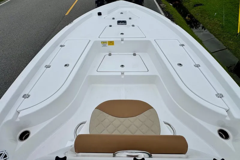 Slide: The Image of 2024 NauticStar 214 Bay boat interior with storage compartments and cushioned seating. - 12