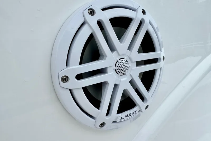 Slide: The Image of White JL Audio speaker on 2024 NauticStar 214 Bay boat exterior. - 16