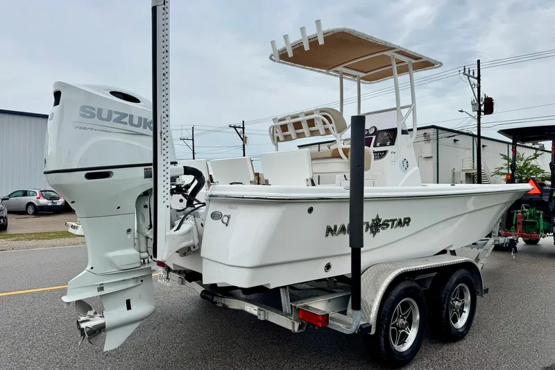 Slide: The Image of 2024 NauticStar 214 Bay boat with Suzuki outboard motor on a trailer. - 4