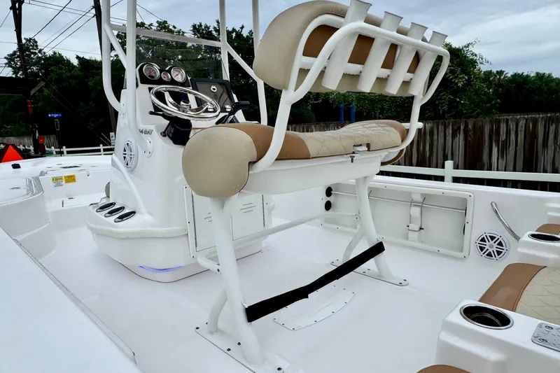 Slide: The Image of 2024 NauticStar 214 Bay boat interior with helm, seating, and fishing rod holders. - 8