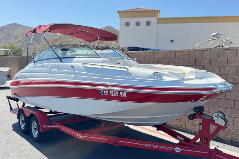 Slide: The Image of 2003 Four Winns 214 Funship boat with red and white design on a trailer. - 1