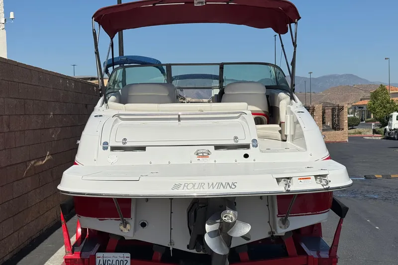 Slide: The Image of 2003 Four Winns 214 Funship boat with red canopy, parked outdoors. - 4