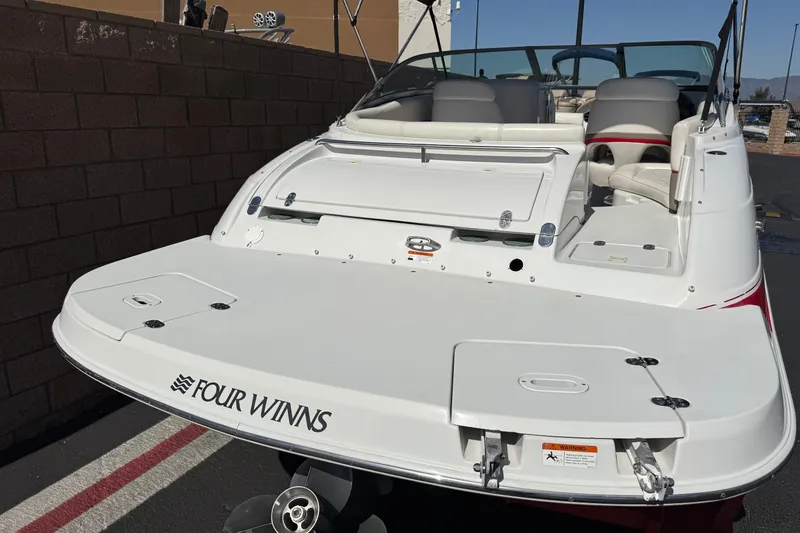 Slide: The Image of 2003 Four Winns 214 Funship boat, rear view, showcasing spacious deck and seating area. - 6