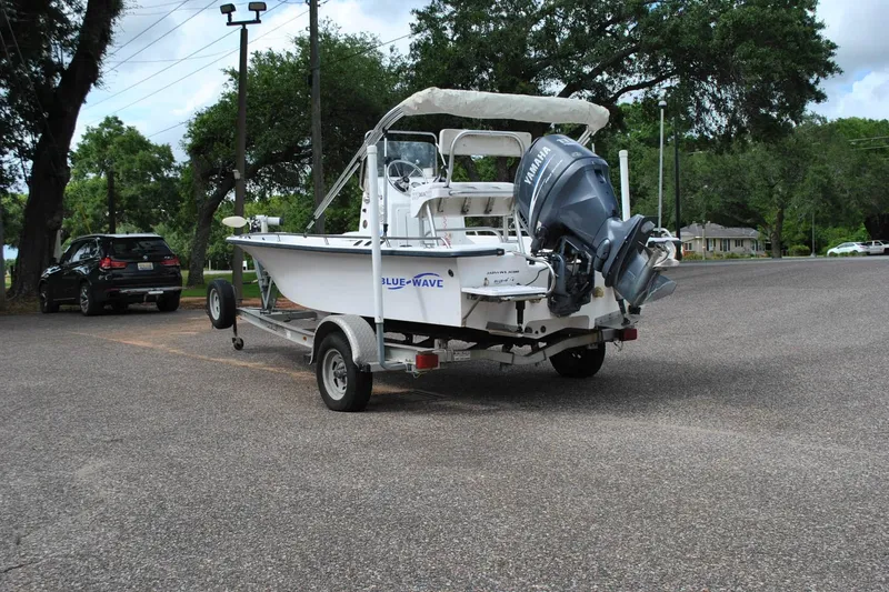 Slide: The Image of 2007 Blue Wave 180 V-Bay boat on trailer in parking lot, surrounded by trees. - 11