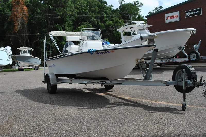 Slide: The Image of 2007 Blue Wave 180 V-Bay boat on trailer, parked near Yamaha and Mercury signs. - 4