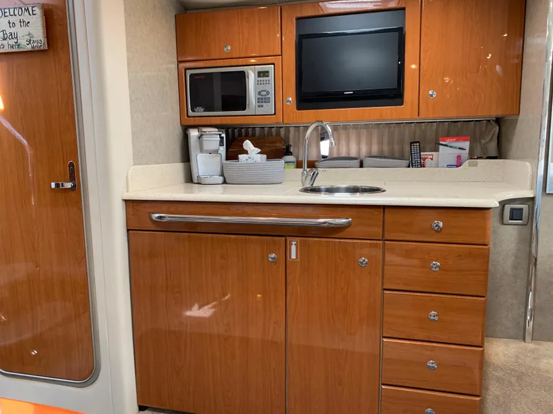 Slide: The Image of 2005 Formula 34 Performance Cruiser kitchen with wood cabinets, microwave, TV, and sink. - 25